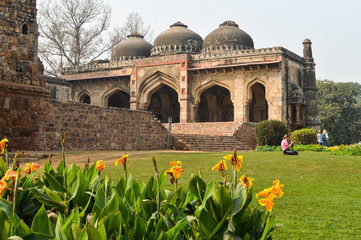 A bada gumbad monument at lodi garden or lodhi gardens in a city park from the side of the lawn at winter foggy morning.