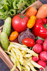 Fresh ripe vegetables in wooden box as healthy snack containing vitamins