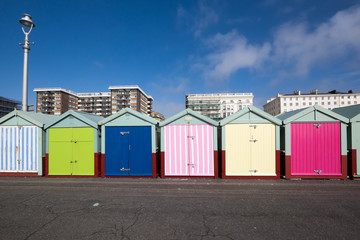 Naklejka premium Beach huts on Hove seafront in Brighton, Sussex, UK, with apartment block buildings