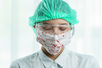 Blood Spilled on doctor's safety glasses, gloves and protective mask.