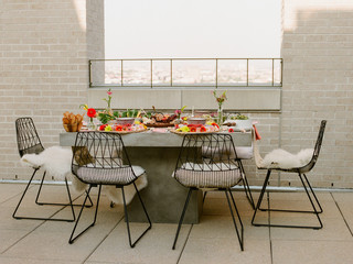 A beautifully decorated table set up on a rooftop for an outdoor dinner