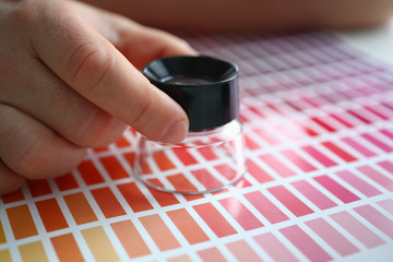 Employee refueling cartridge service holds magnifying glass in hand. Color print of statistics...