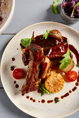 Baked ribs with homemade potatoes and coleslaw salad in white plate