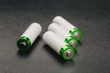 Close the positive poles of the used battery on a black background.