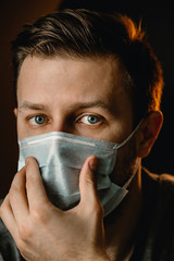 A man in a protective mask looks at the camera. Virus protection, self-isolation.