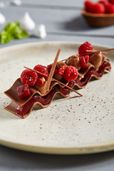 Fleur de lys milk chocolate with raspberry confit in white ceramic plate
