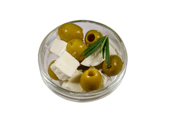 Feta cheese cubes with green olives and rosemary in glass bowl isolated on white background