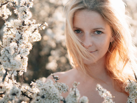 Beautiful blond woman portrait with blooming flowers