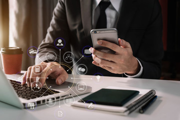 Female businessman hand working digital marketing media in virtual screen with mobile phone and modern compute with VR icon diagram at office in morning light. 