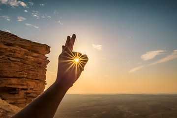 Sun rays through fingers - Edge of the world Saudi Arabia. ( Selective focus on subject and...