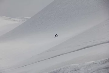 Fotobehang 起伏のある雪山に二人のスキーヤーがいる風景 © misumaru51shingo