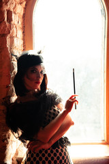 Retro image of beautiful woman near window with mouthpiece