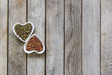 Sichuan red and green peppercorn close-up in heart-shape plate on wooden board background