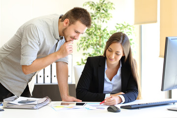 Two executives looking at graph reports in the office