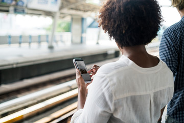 Woman waiting and playing on her phone