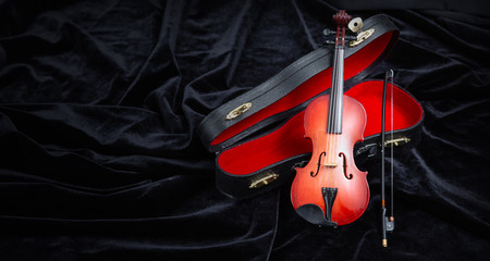 violin with a case on dark velvet