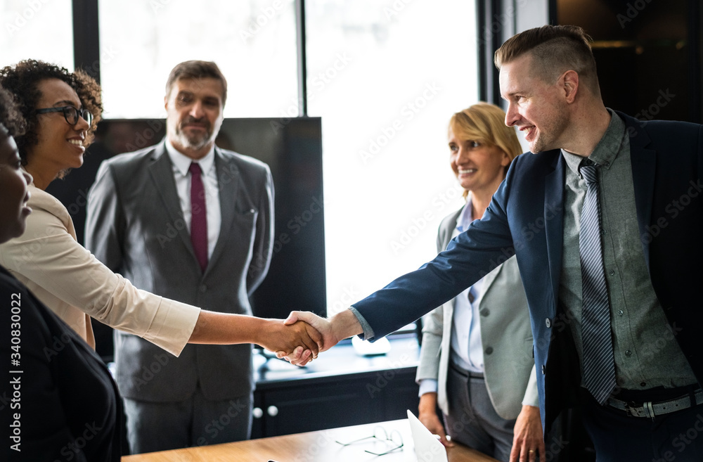 Wall mural business people shaking hands in a meeting room