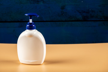 White sanitizer container isolated on orange background with blue head