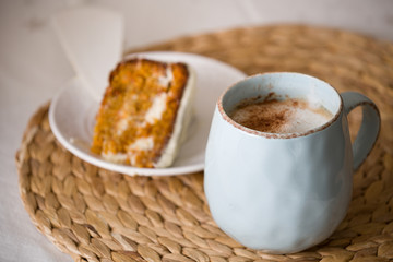 Closeup of a cup with coffee and a slice of homemade cake on a plate. Homemade baking. Selective focus. Celebration and holidays concept.