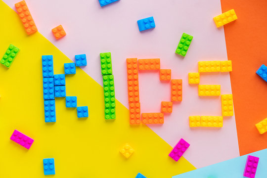 Kids spelled word with plastic blocks background