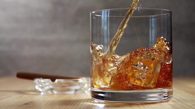 Pouring Whiskey into a Glass With Ice. Slow Motion