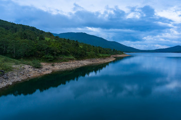 Fototapeta na wymiar Mountain lake landscape. Nozori lake, dam surrounded by mountains