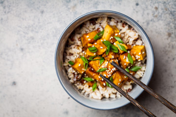 Marinated tofu with sesame seeds, green onions and brown rice, top view. Asian food concept. - obrazy, fototapety, plakaty