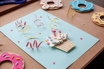 Paper cutting cupcake on blue background. Handmade art work. Colorful sprinkles, dot and star, for your birthday card design. 