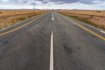 Road background with straight asphalt road and fields