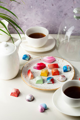 Morning coffee with chocolate candies on white table