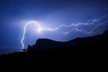 Powerful lightning over a rock on the Black sea coast
