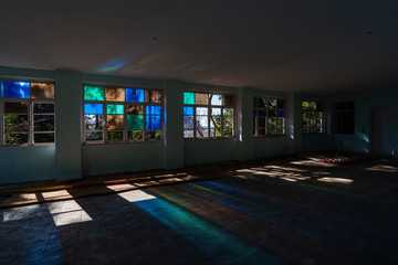 Multicolored sun rays on the floor of an abandoned building