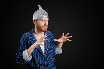 scared man in foil cap and old holey bathrobe