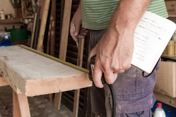 Male carpenter working on old wood in a retro vintage workshop.