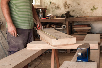 Male carpenter working on old wood in a retro vintage workshop.