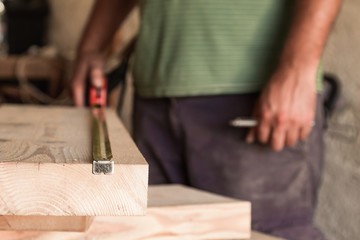 Male carpenter working on old wood in a retro vintage workshop.