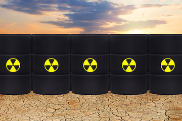 Radioactive waste against dry earth and sky clouds. Environment protection and toxic nuclear...