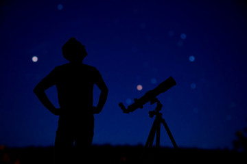 Amateur astronomer looking at the stars with a telescope. Astronomy and astrology concept.