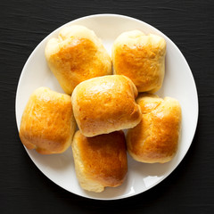 Home-baked Beef Russian Bierocks on a white plate on a black background, top view. Flat lay, overhead, from above. Close-up.