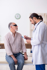 Fototapeta premium Old blind man visiting young male doctor