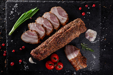 Various sausages and smoked products lie on a black board, sausage, sausages, ribs, rolls. Top view, overhead. Flat lay