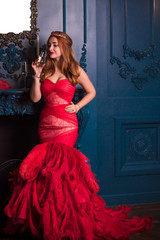 Redhead Woman in red luxury dress with feathers