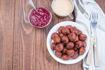 Meatballs served with cream sauce and cranberry jam, swedish cuisine, horizontal, top view, copy space