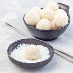 Healthy homemade raw paleo energy coconut balls in ceramic bowl, square format