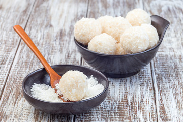 Healthy raw paleo energy balls with shredded coconut, almond flour, coconut butter and sweetener, wooden background, horizontal