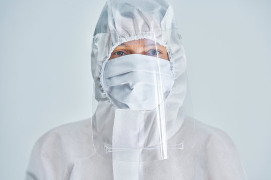 Woman In Bio-hazard Suit And Face Shield On White Background.