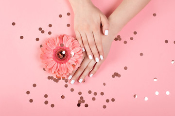 Hands of a beautiful woman on a colorful background. Delicate palm with natural manicure, clean skin. Light pink nails.