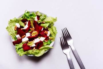 Beetroot, feta cheese and pecans salad on grey concrete table. Selective focus