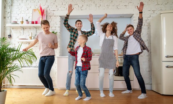 The Group Of Young Friends Is Dancing In The Kitchen, Happiness, Joy, Community. Cooking Togther And Having Fun