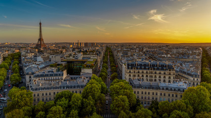 Paris sunset skyline aerial view from top of Arc de Triomphe on Champs Elysees street. Distant Tour...